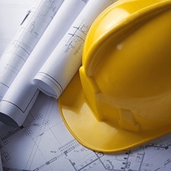 yellow-hard-hat-and-design-construction-plans